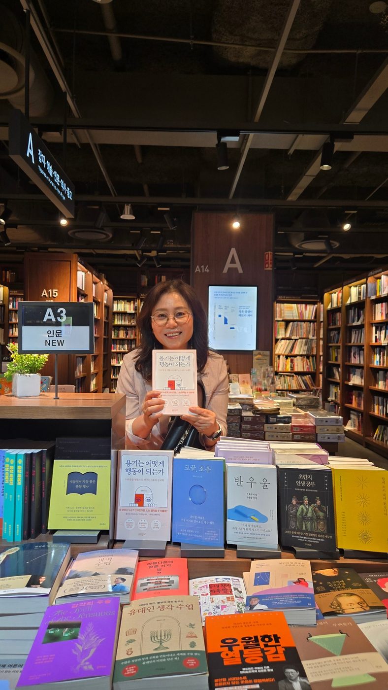 인문 신간 매대 앞에서 『용기는 어떻게 행동이 되는가』를 든 김명순 작가